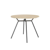 Mesa de jantar redonda 1588 Carraro com tampo off white e estrutura preta de pés inclinados, vista em ângulo
